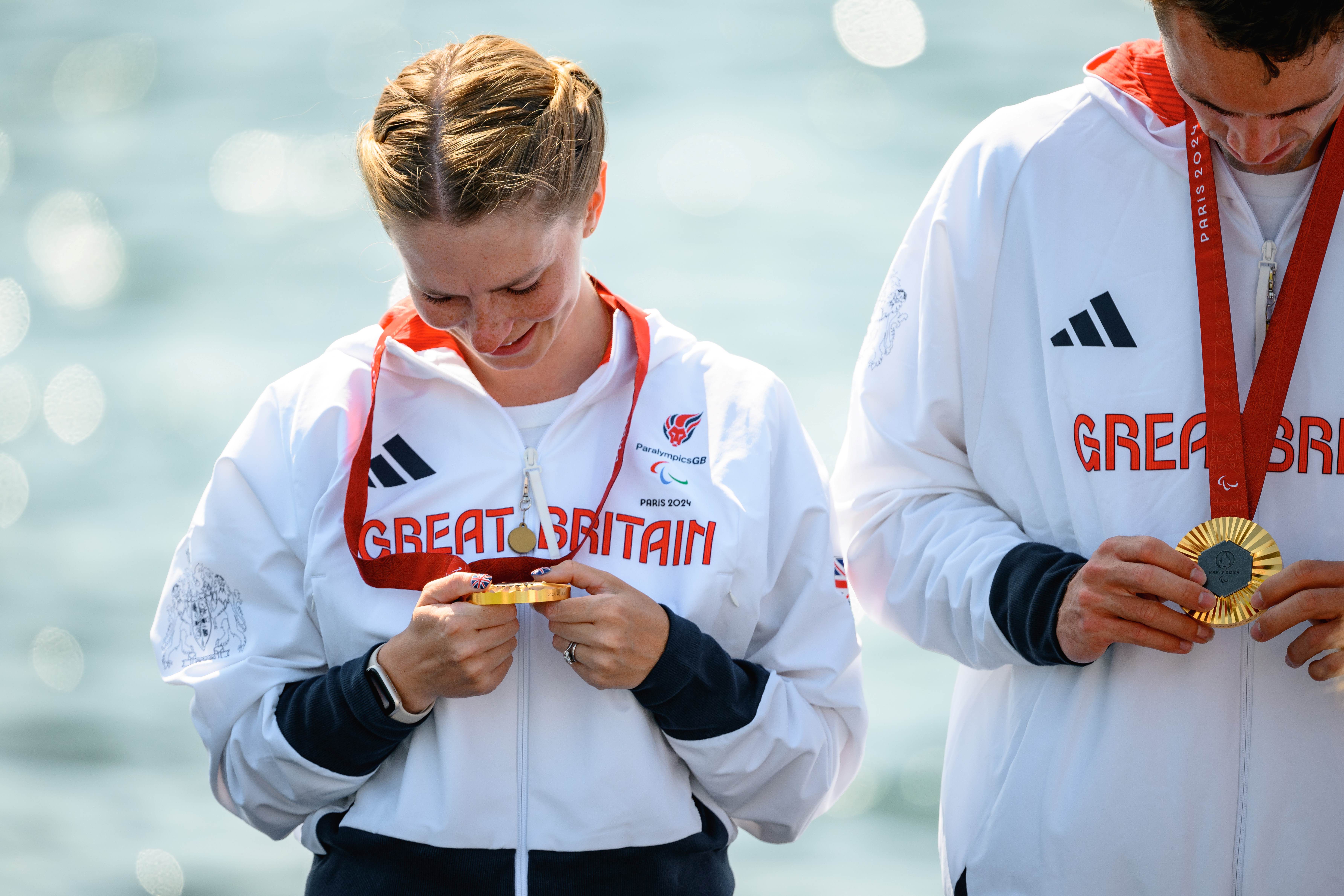 Erin Kennedy holding and looking down at her gold medal.