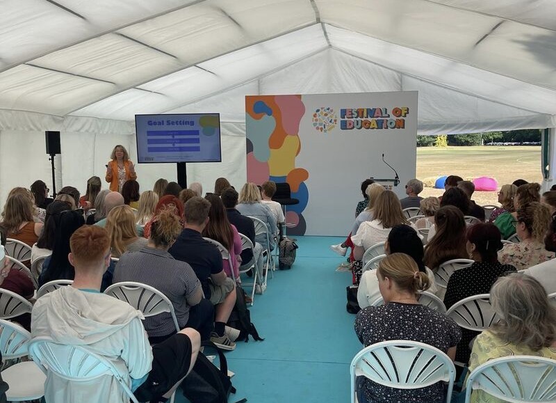 Dyedra Morrissey stood speaking in front of seated audience in marquee