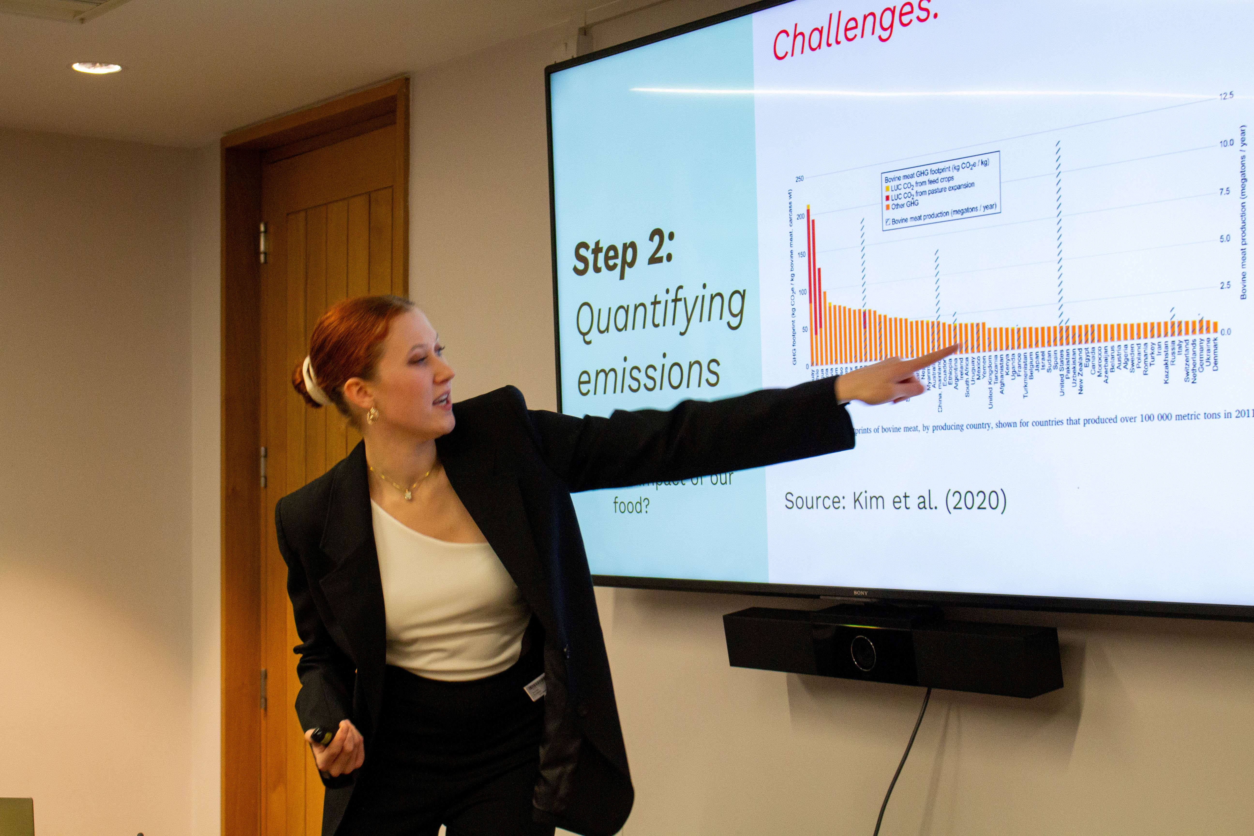 Hanna pointing to her presentation on a screen.