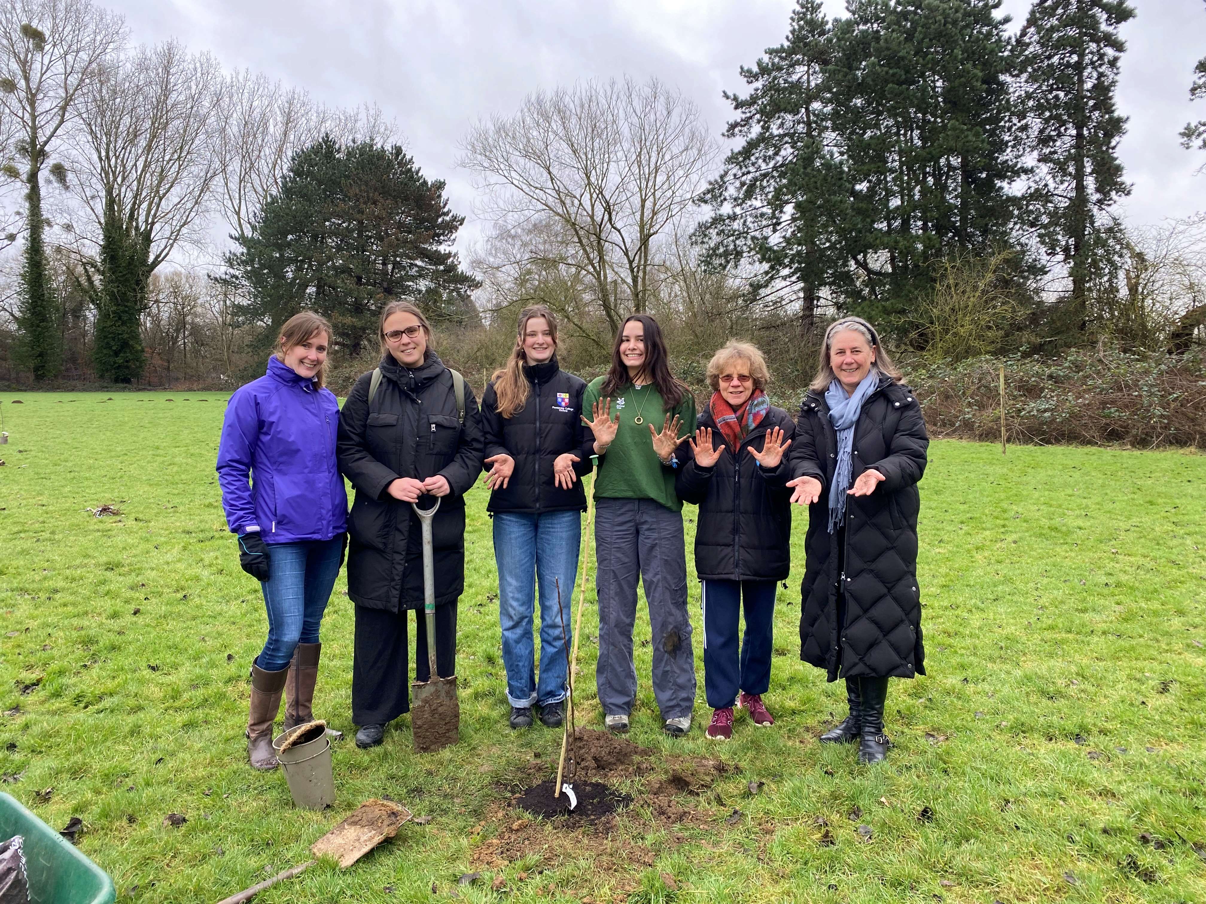 Group standing in field showing muddy hands