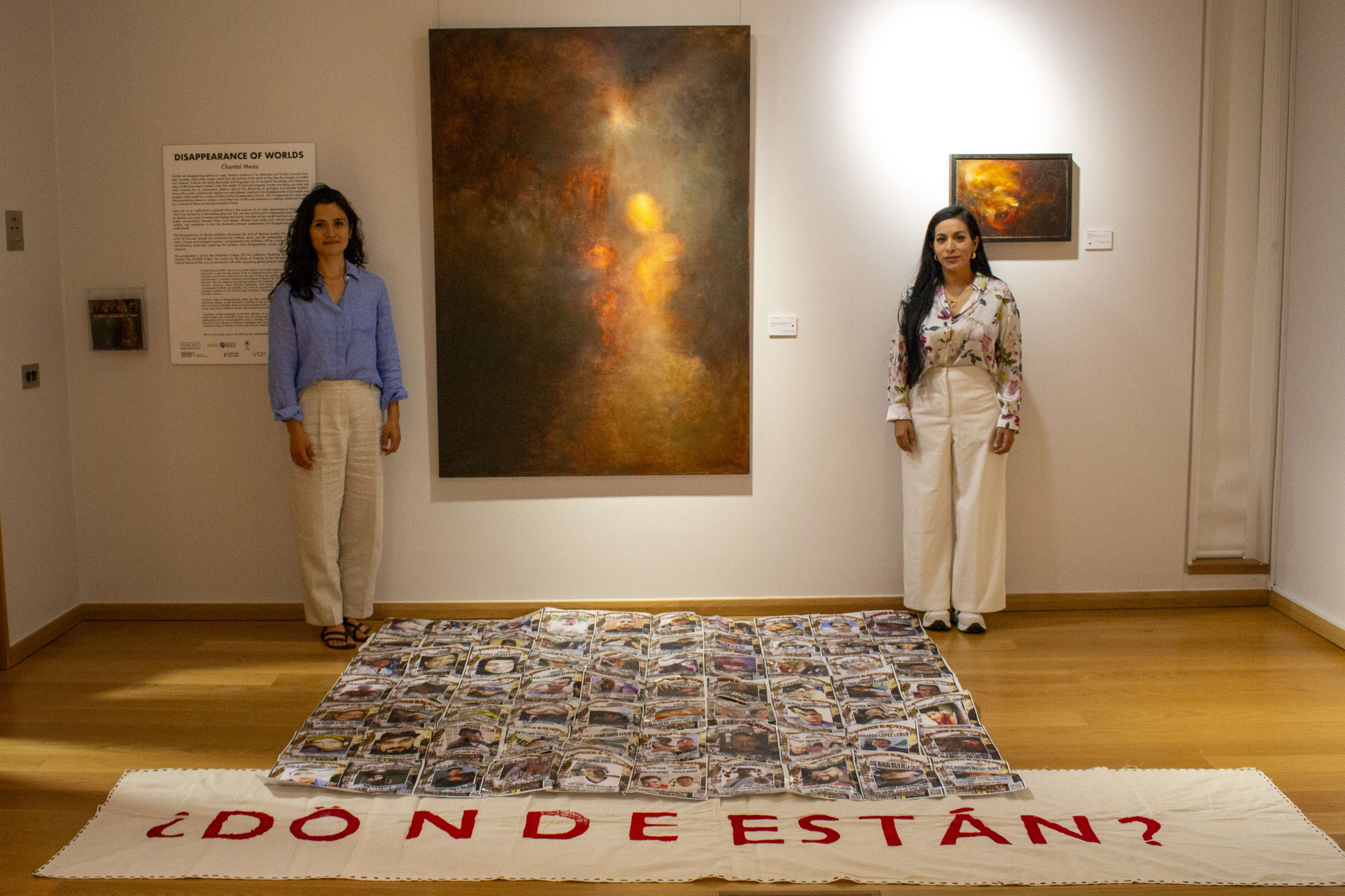 Chantal Meza and Indira Navarro standing beside Meza's painting 'Dreams of Disappearance'.