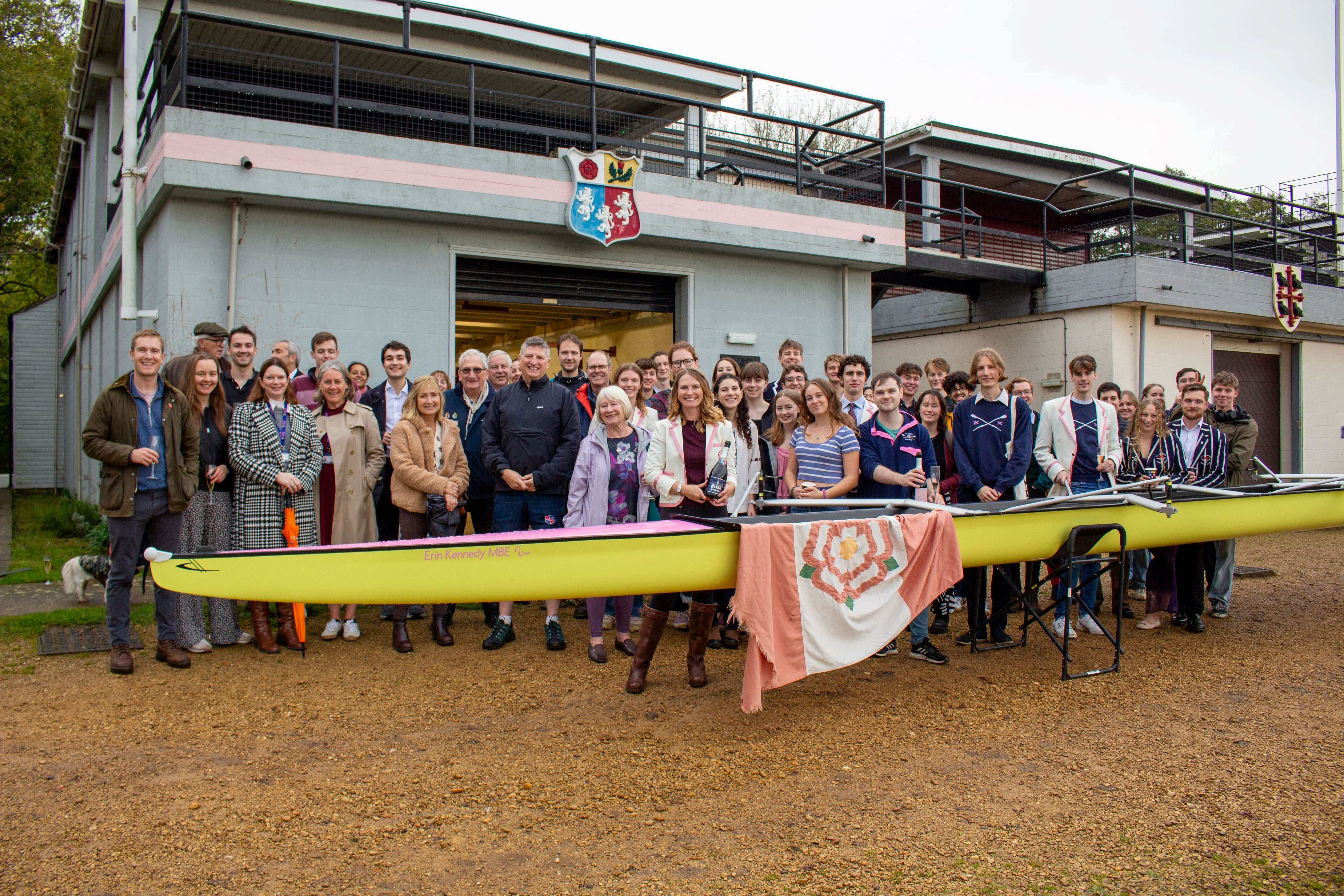 Members of PCBC gathered by the new women's boat in front of the Boat House.