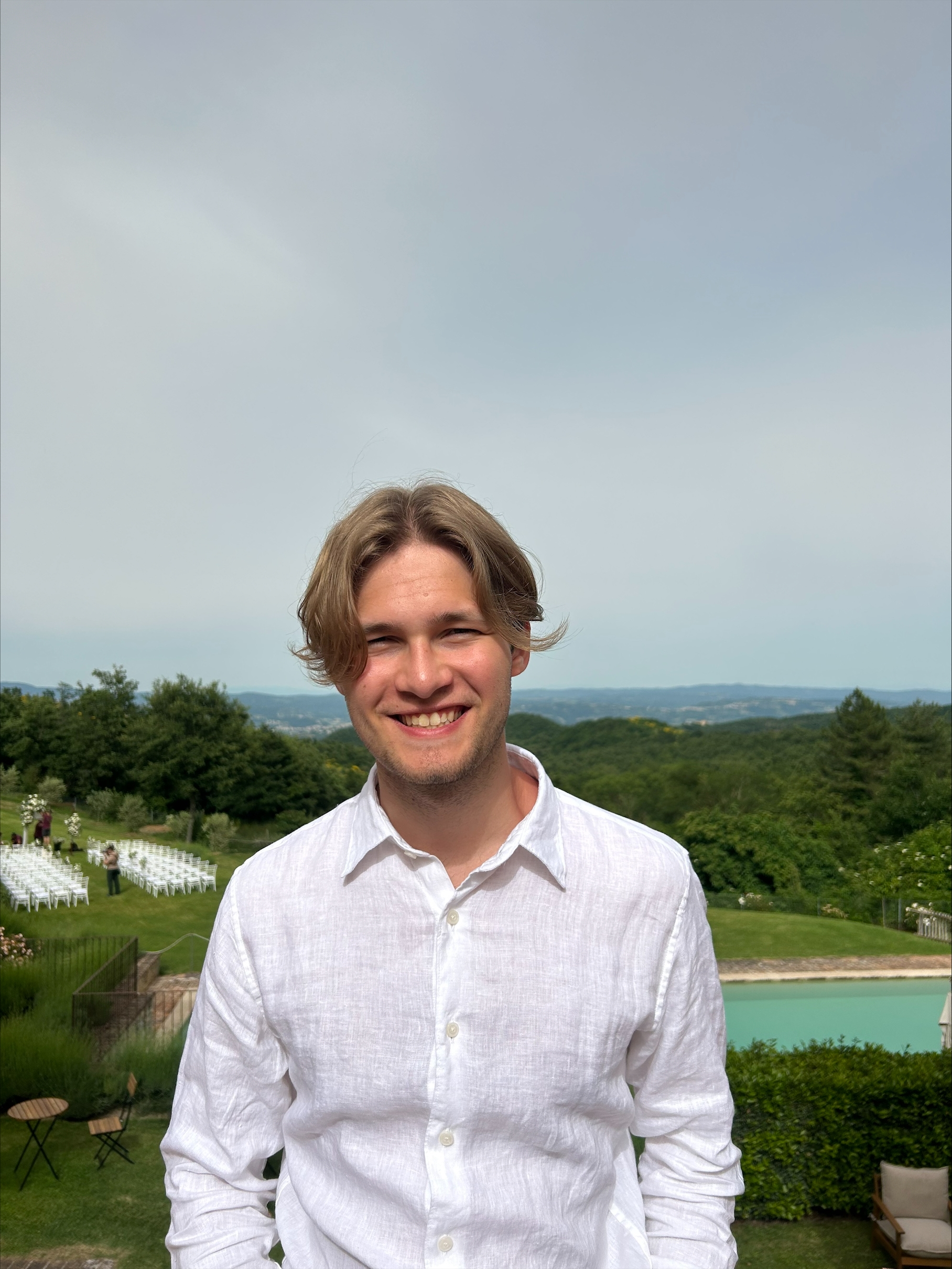 Joel smiling with green scenery behind him