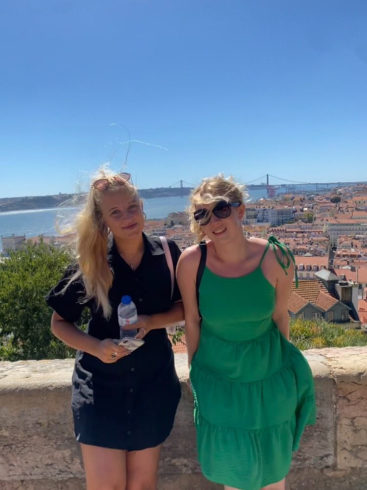 Olivia and Cassie with a view of the sea behind them in Lisbon