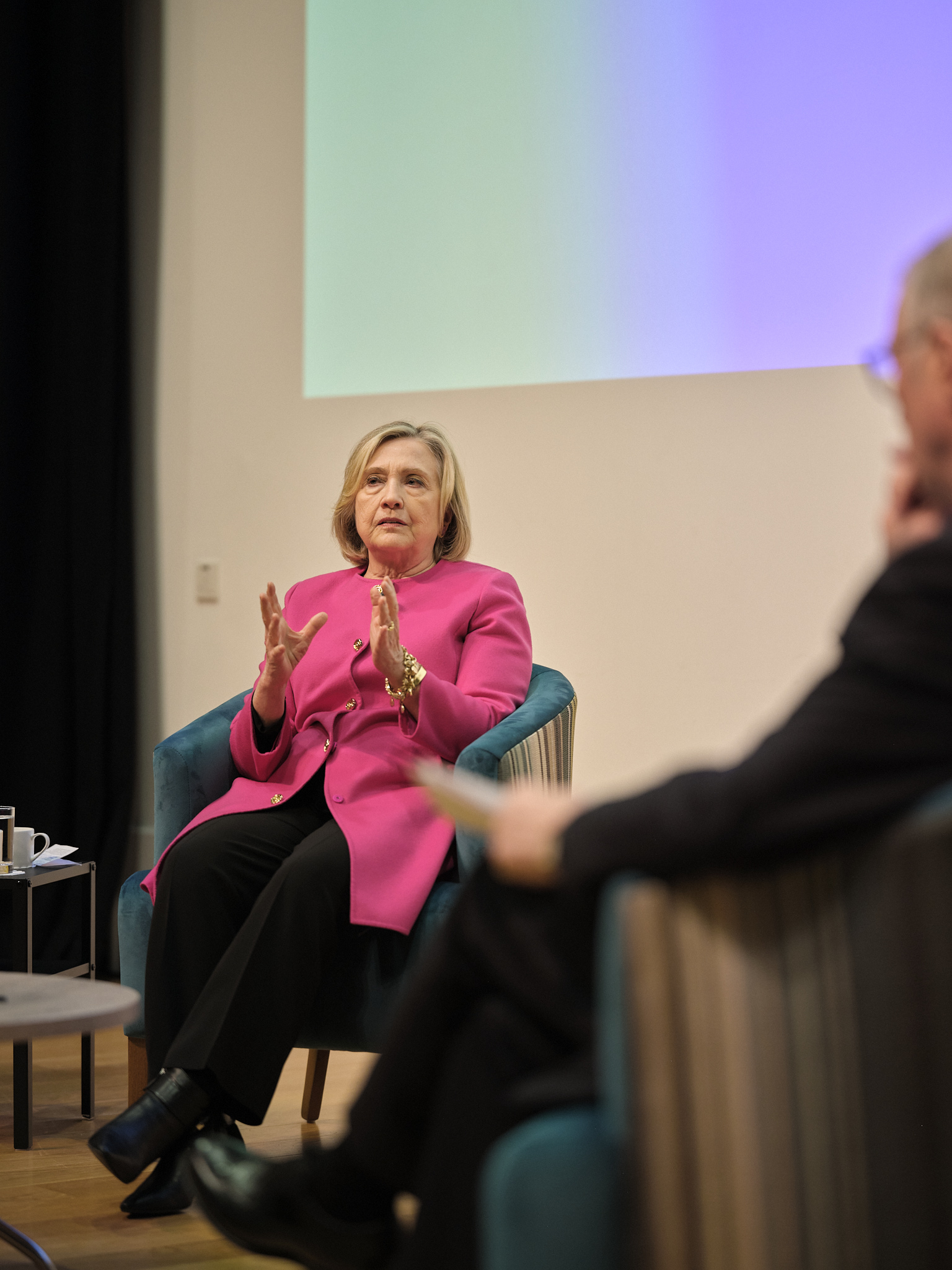 A close-up of Secretary Hillary Rodham Clinton, who is speaking and gesturing with her hands.