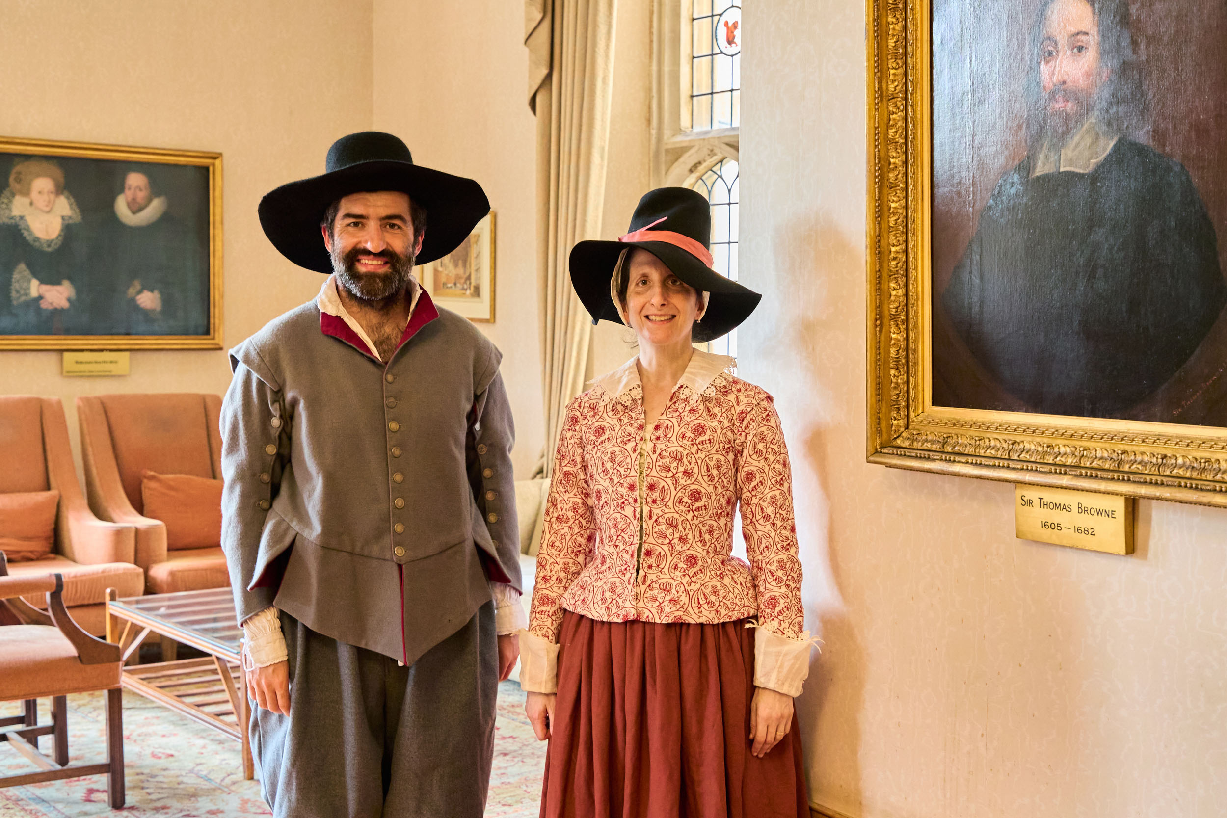 Tamsin Lewis and Richard de Winter pose in front of a portrait of Thomas Browne, who gave the original speech at the Foundation Ceremony.