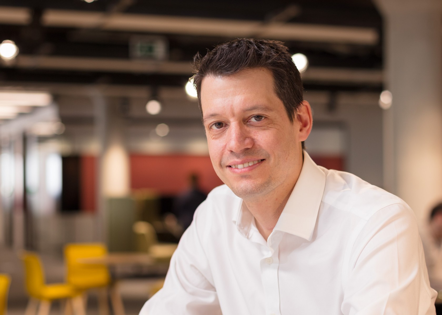 Headshot of Gareth Powell, he is wearing a white shirt and smiling. Background is slightly blurred.