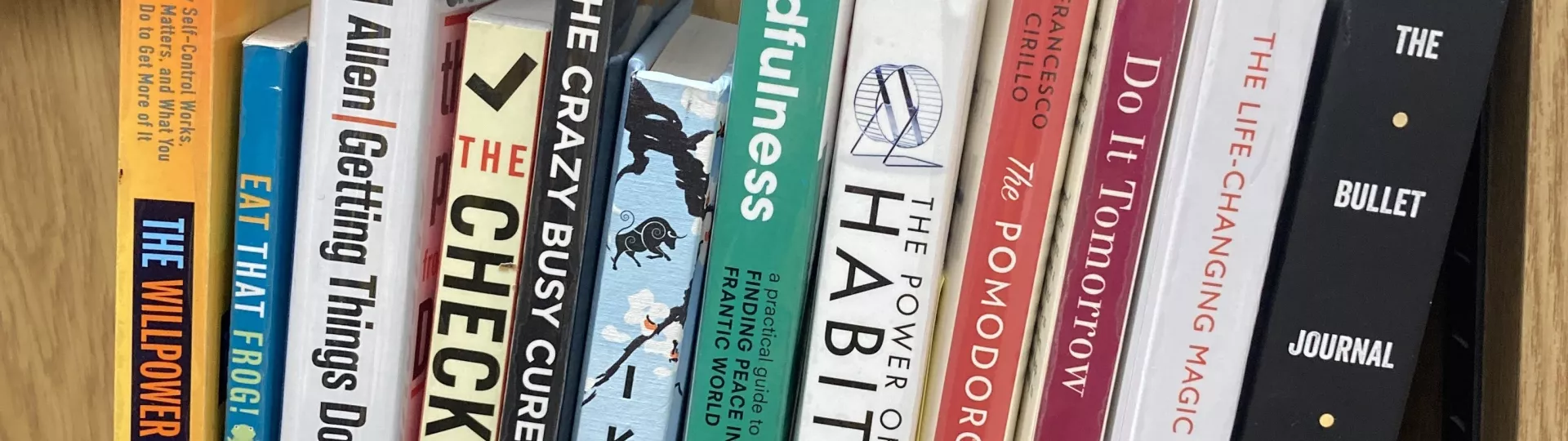 A row of productivity books on a shelf