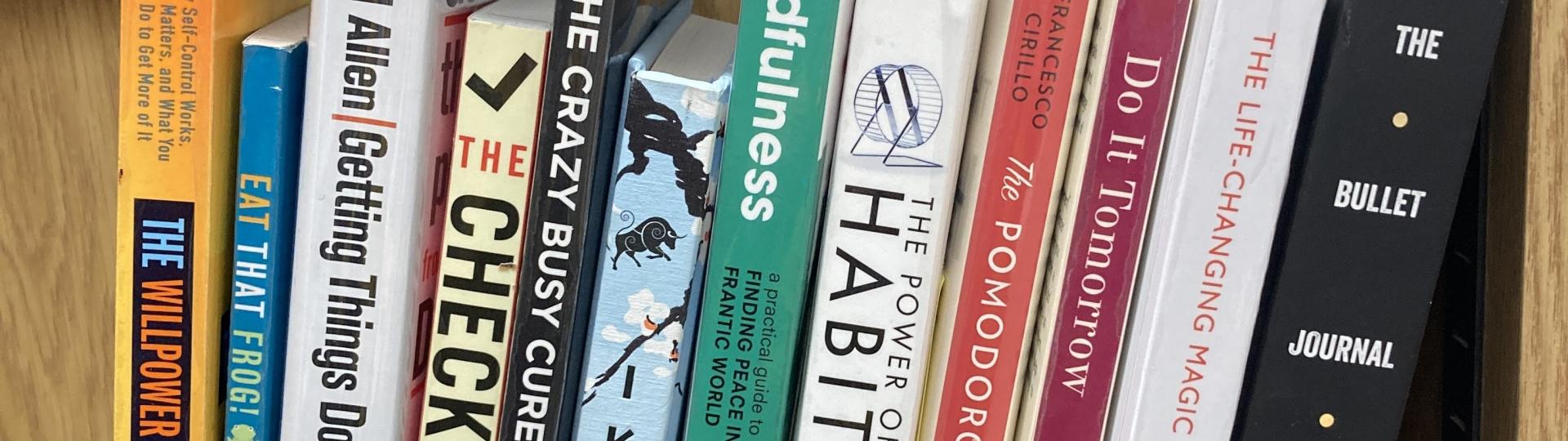 A row of productivity books on a shelf