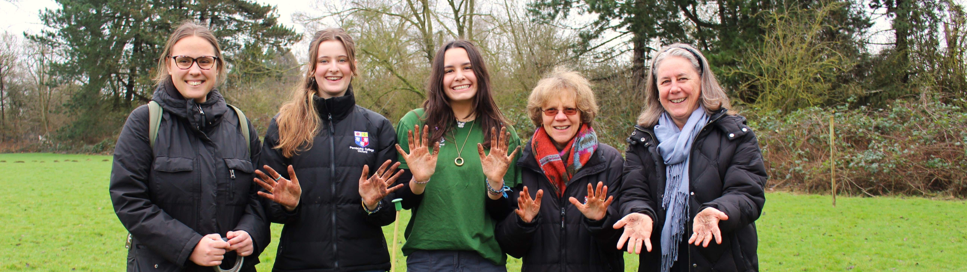 Group in field showing muddy hands