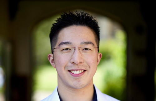 Head shot of Oscar Lu, smiling, with Chapel Quad in background