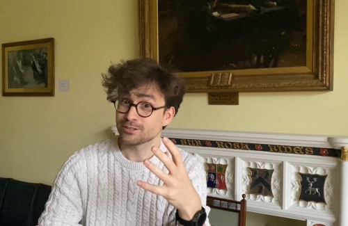 Benjamin Breant gestures mid-speech in the SCR Parlour.